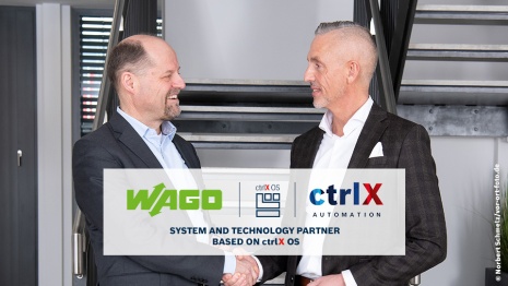 Two men in suits smiling as they shake hands. In the foreground, the logos of WAGO, ctrlX OS, and ctrlX AUTOMATION are displayed. Below it reads: System and Technology Partner Based on ctrlX OS.